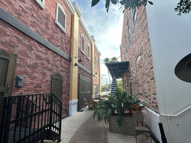 A view of an alley way with brick buildings.
